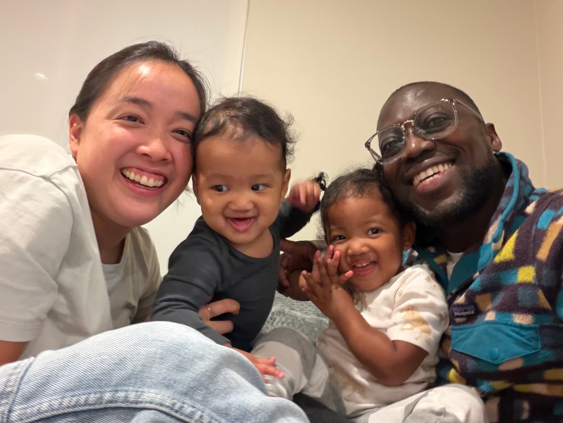 Christine and Mark smiling with their two young children squeezed between them